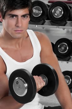 Portrait of a man exercising with dumbbell in a gym