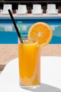 Glass of orange juice at the poolside