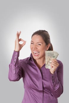 Woman holding currency notes and showing OK sign