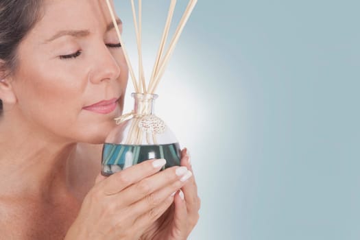 Woman holding an aromatherapy oil bottle with incenses