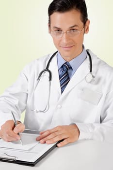 Portrait of a doctor writing on a clipboard