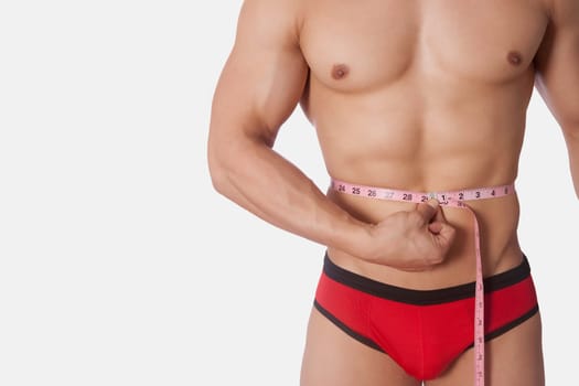 Man measuring his waist with a tape measure