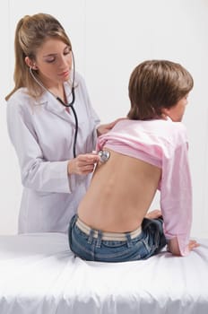 Female doctor examining a boy with a stethoscope