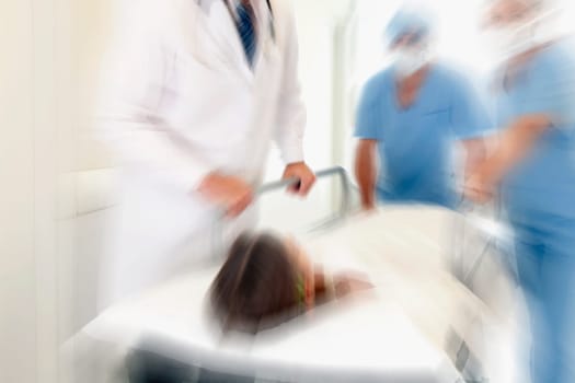 Doctors pushing a patient on a hospital Gurney in a hospital corridor