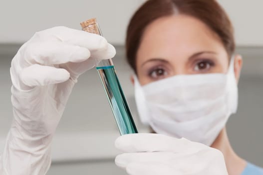 Female lab technician analyzing a sample in a test tube