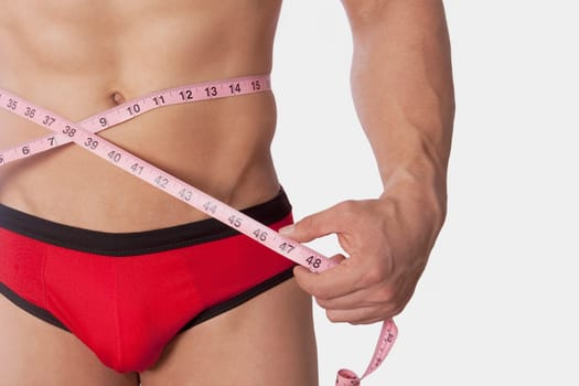 Man measuring his waist with a tape measure