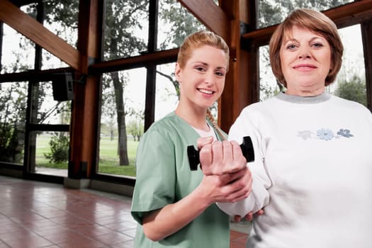 Physiotherapist helping a disabled woman in exercising