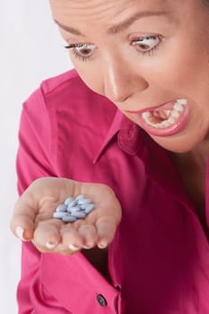 Woman looking at pills and shouting