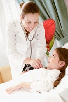 Girl on a hospital bed being examined by a female doctor