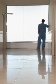 Surgeon looking through a window in a hospital