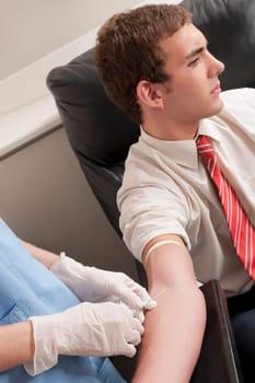 Doctor taking blood sample of a man