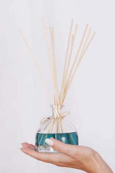WomanŽs hand holding an aromatherapy oil bottle with incenses