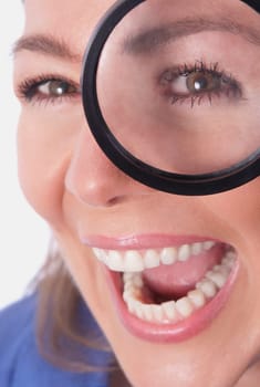 Woman looking through a magnifying glass and laughing