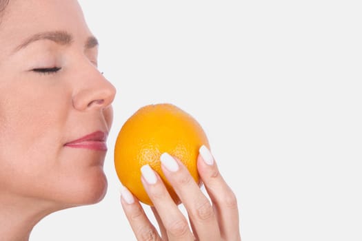 Woman smelling an orange
