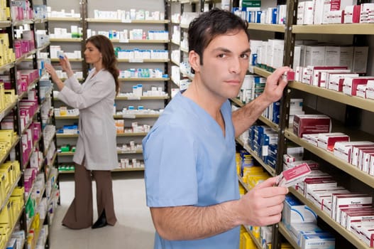 Male and a female pharmacist checking the medicines in the medical store