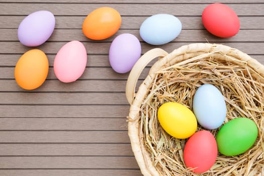 Close up Colorful easter eggs in the basket on wood background with space