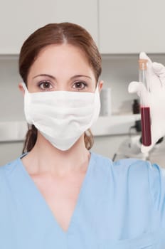 Female lab technician analyzing a blood sample in a test tube
