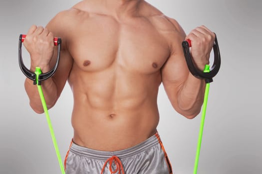 Mid section view of a man exercising with resistance band