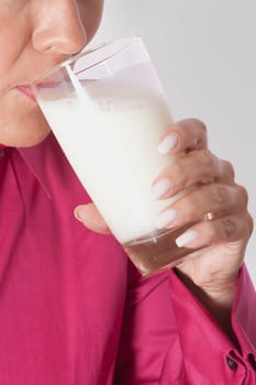 Close_up of a woman drinking milk from a glass