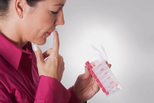 Woman looking at a pill box