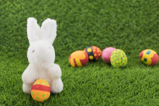 Easter bunny toy and Easter eggs on green grass
