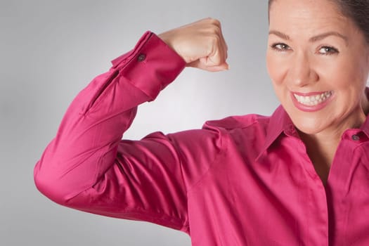 Portrait of a woman flexing her muscles and smiling