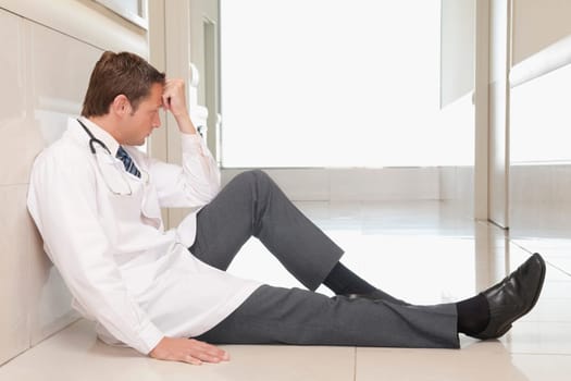 Doctor sitting on the floor looking depressed