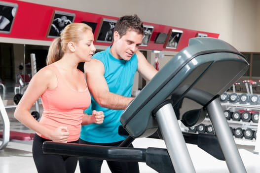 Man assisting a woman on a treadmill