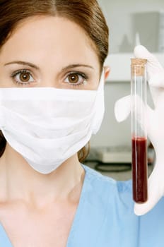 Female lab technician holding blood sample in a test tube