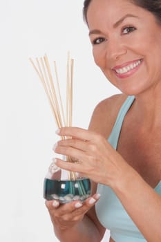 Woman holding an aromatherapy oil bottle with incenses
