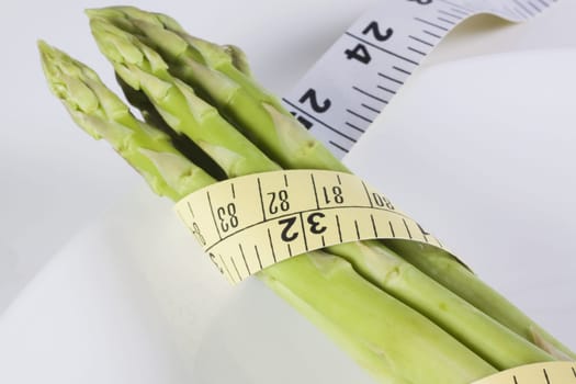 Close_up of a tape measure wrapped around asparagus stalks