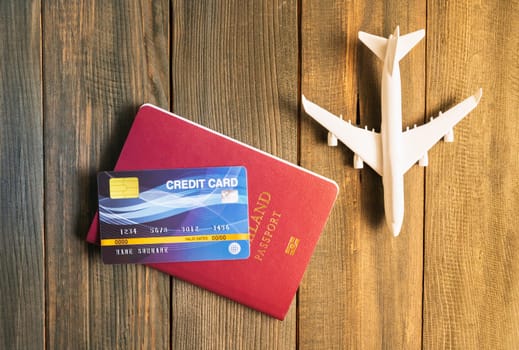 Credit card put on passport and airplane model on wooden table , Preparation for Traveling concept