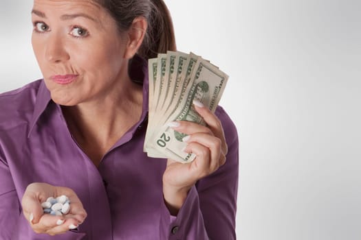 Woman holding pills and currency notes