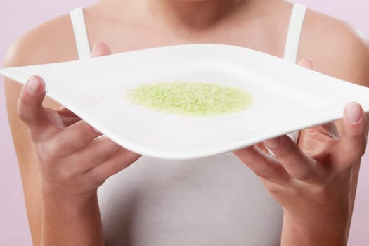 Mid section view of a woman holding a tray of bath salt