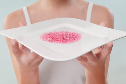Mid section view of a woman holding a tray of bath crystals