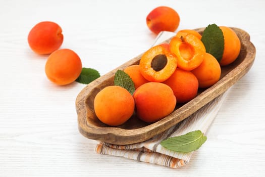 Apricots. Ripe fresh apricots on a wooden white background..
