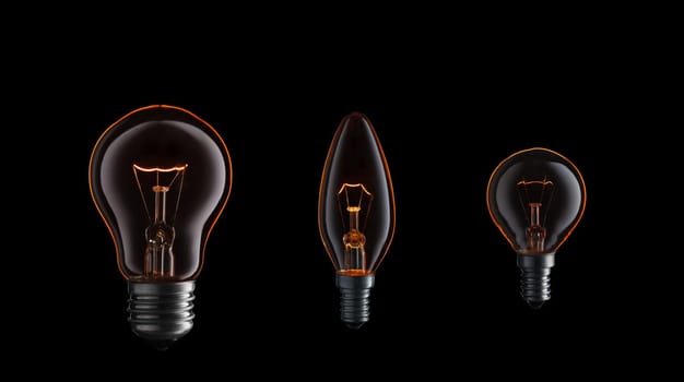 Collection of light bulbs with fire and smoke on black background.