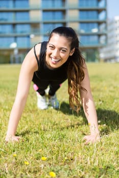 A beautiful young woman making some exercise at the park - fitness concept