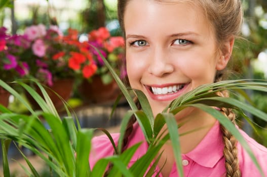 Woman holding a potted plant in a greenhouse