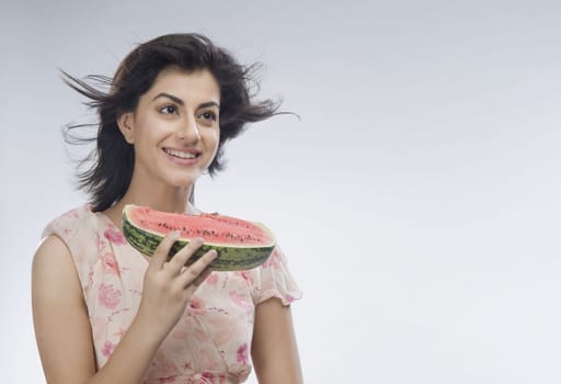 Woman eating watermelon and day dreaming