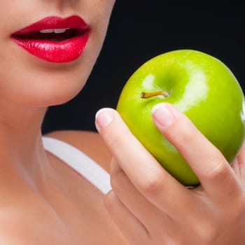 Close_up of a woman holding a granny smith apple