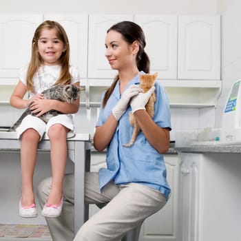 Female vet with a girl carrying cats
