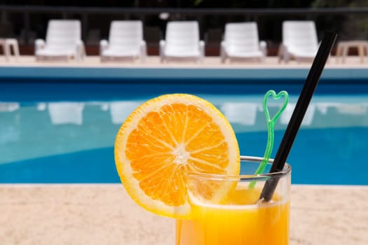Glass of orange juice at the poolside