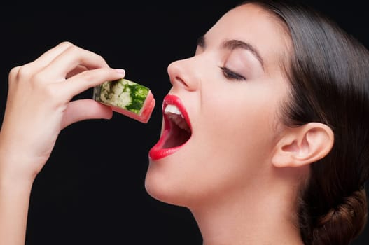 Close_up of a woman eating a watermelon slice