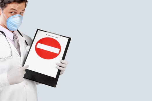 Doctor wearing a flu mask and showing Do Not Enter sign