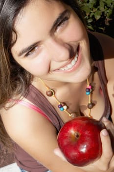 Portrait of a woman holding an apple and smiling