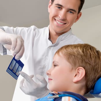 Dentist showing an X_Ray report to a boy