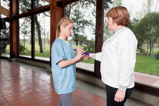 Health worker putting on a wrist brace to a disabled woman