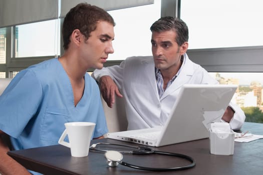 Doctors using a laptop in a cafeteria