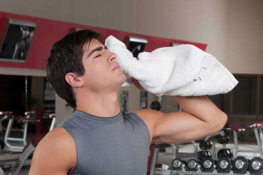 Close_up of a man wiping his face with a towel